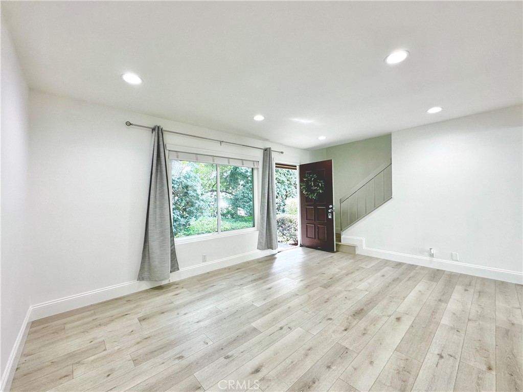 13 Greenleaf, Unit 5 Irvine, CA 92604 - Photo 5 of 30 a view of an empty room with wooden floor and a window