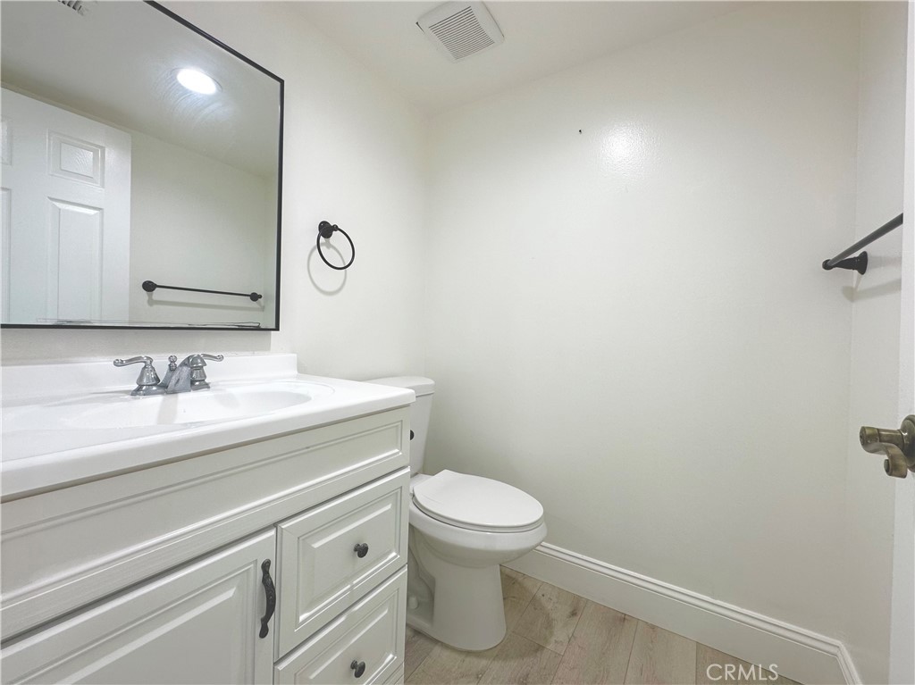 13 Greenleaf, Unit 5 Irvine, CA 92604 - Photo 7 of 30 a bathroom with a granite countertop sink a toilet and a mirror