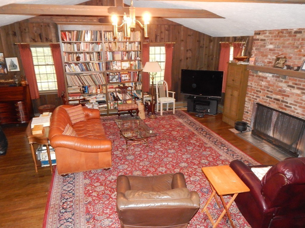 266 Old Pickard Road Concord, MA 01742 - Photo 11 of 30 a living room with furniture a flat screen tv and a floor to ceiling window