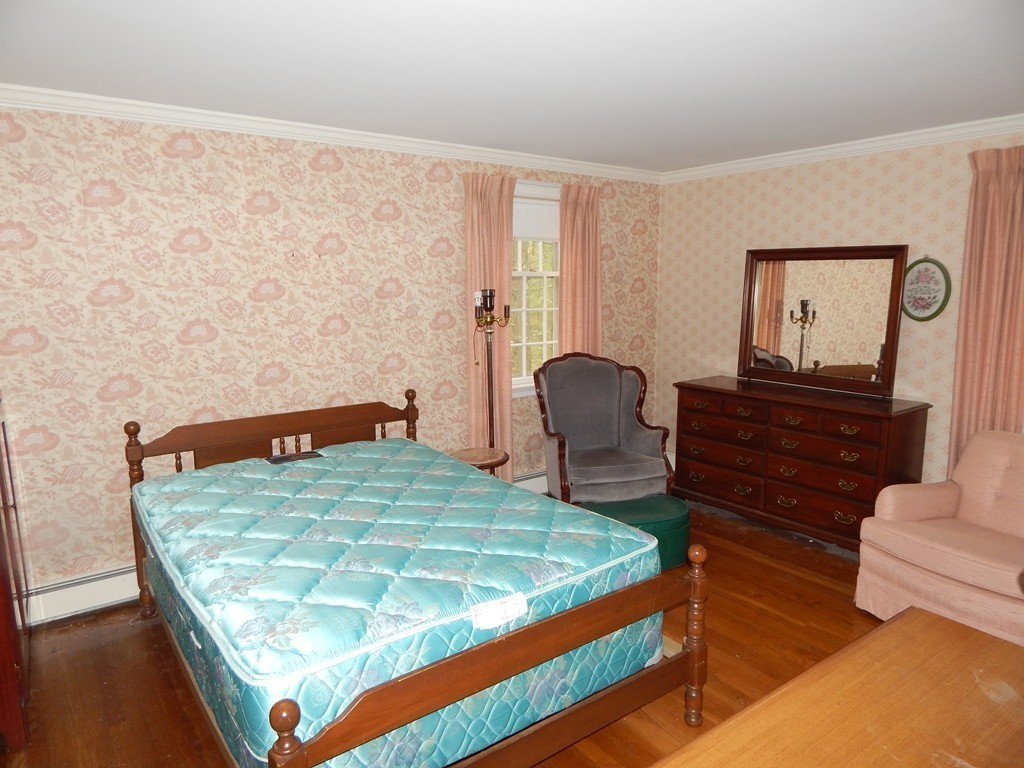 266 Old Pickard Road Concord, MA 01742 - Photo 21 of 30 a bed sitting in a bedroom next to a window with chair