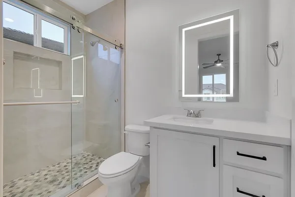 a bathroom with a sink a toilet and shower