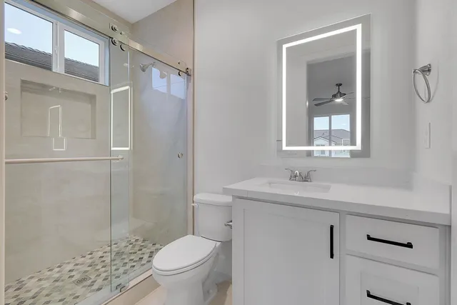 a bathroom with a sink a toilet and shower