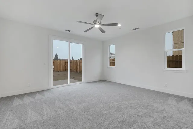 an empty room with closet and a ceiling fan
