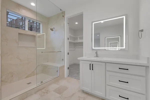 a bathroom with a shower sink and mirror