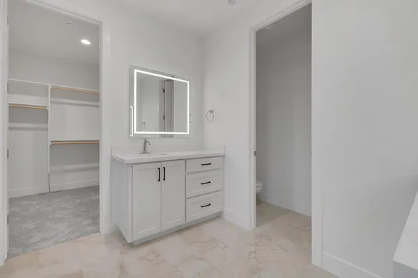 a view of an empty room with cabinet and mirror