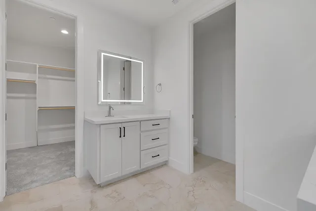 a view of an empty room with cabinet and mirror