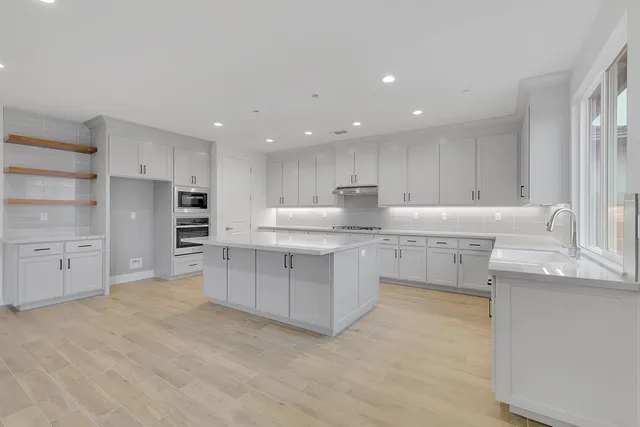 a kitchen with white cabinets stainless steel appliances and a sink