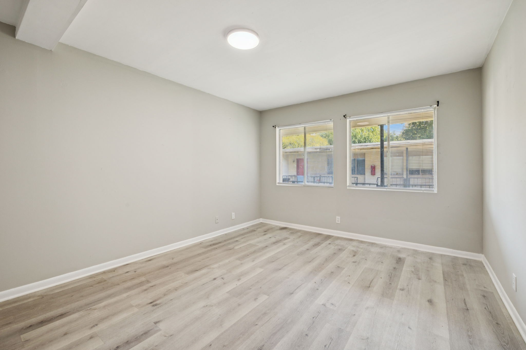 550 Harding Place, Unit D113 Nashville, TN 37211 - Photo 13 of 20 an empty room with wooden floor and windows
