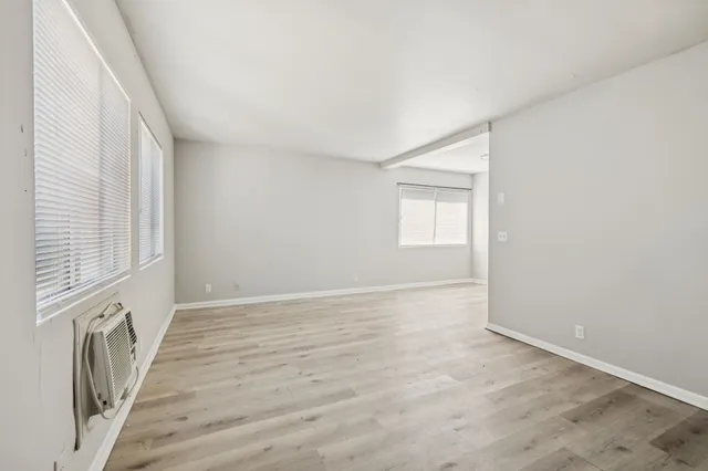an empty room with wooden floor and a window
