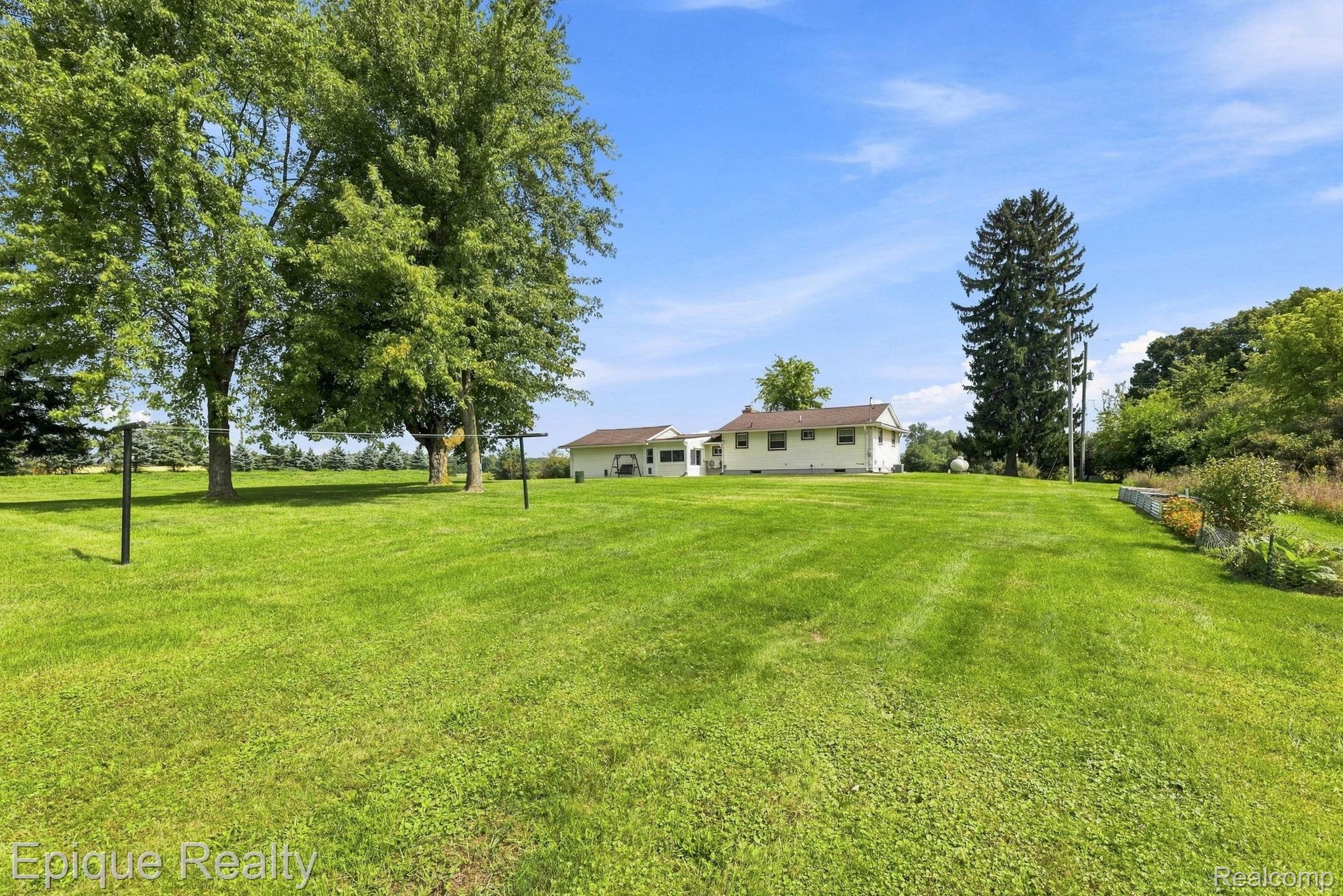 10091 North Genesee Road Mount Morris, MI 48458 - Photo 28 of 35 Expansive green lawn with mature trees and a single-story residence