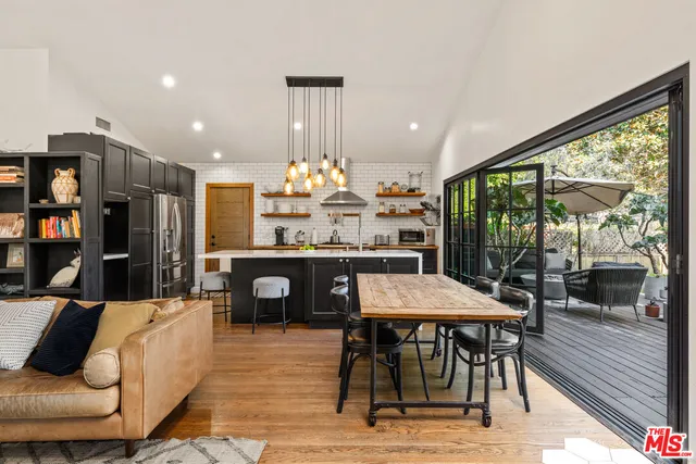 a living room with stainless steel appliances furniture kitchen view and a large window