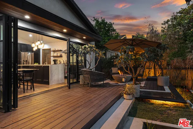 a view of a patio with table and chairs a barbeque with wooden floor and fence