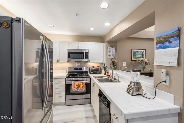 a kitchen with stainless steel appliances a stove a sink and a refrigerator