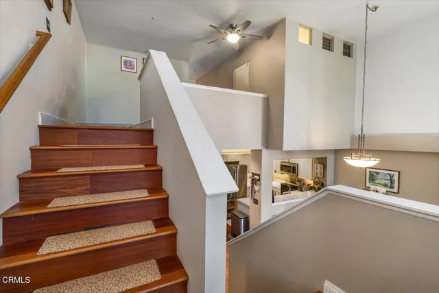 a view of staircase and kitchen view with wooden floor