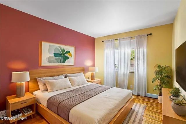 a bedroom with a bed and a painting on the wall