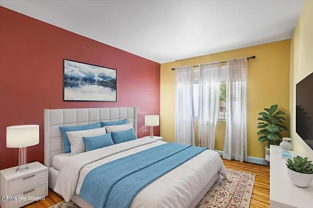 a bedroom with a bed and a potted plant