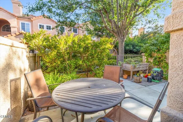 a view of a patio with table and chairs with wooden floor and fence