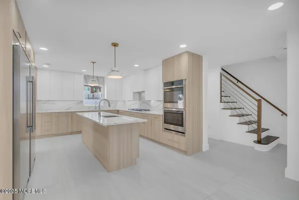 a kitchen with kitchen island a counter top space stainless steel appliances and cabinets