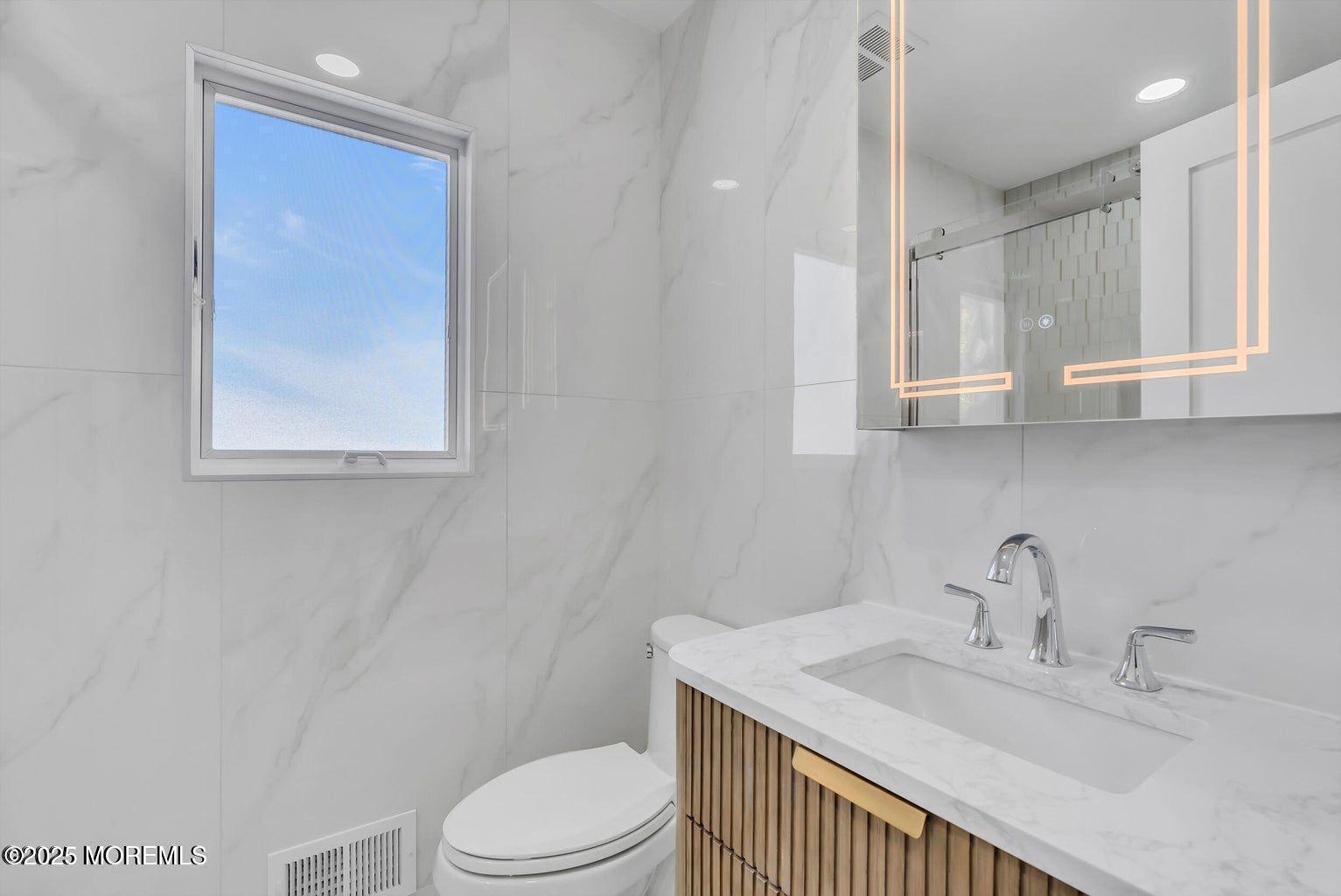 1 Robin Drive Oakhurst, NJ 07755 - Photo 19 of 42 a bathroom with a sink a toilet and vanity