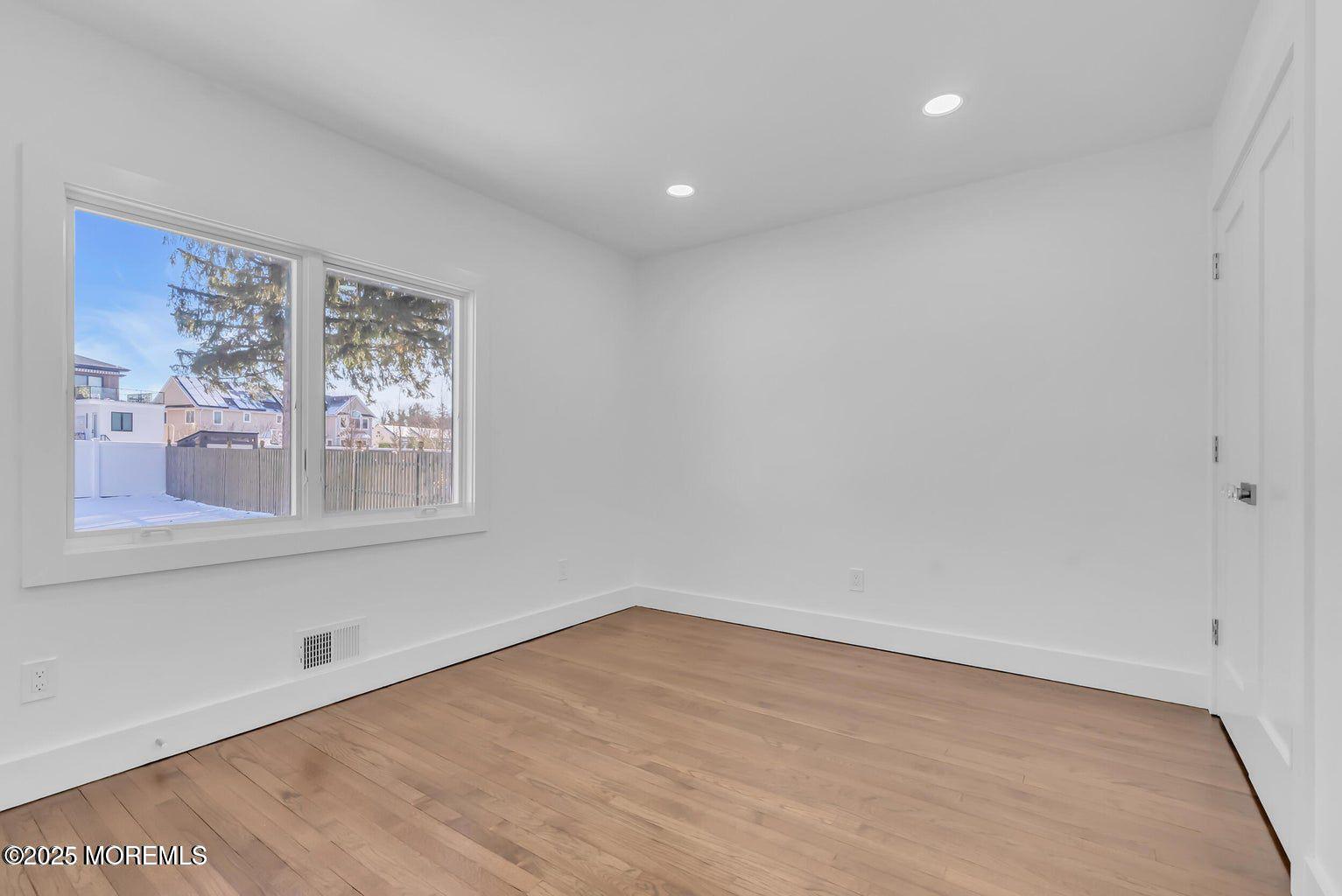 1 Robin Drive Oakhurst, NJ 07755 - Photo 27 of 42 a view of empty room with wooden floor and fan