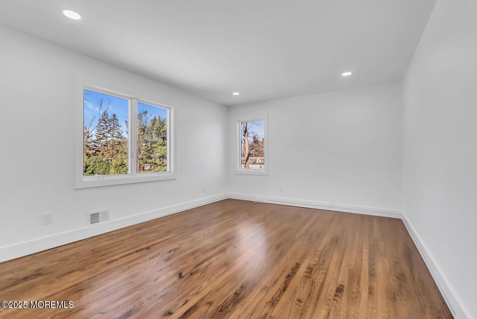 1 Robin Drive Oakhurst, NJ 07755 - Photo 37 of 42 an empty room with wooden floor and windows