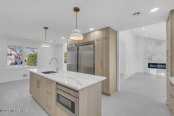 a kitchen with stainless steel appliances granite countertop a sink a stove and a wooden floors