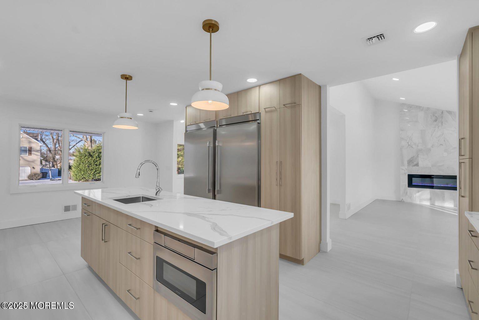 1 Robin Drive Oakhurst, NJ 07755 - Photo 9 of 42 a kitchen with a sink chandelier and refrigerator