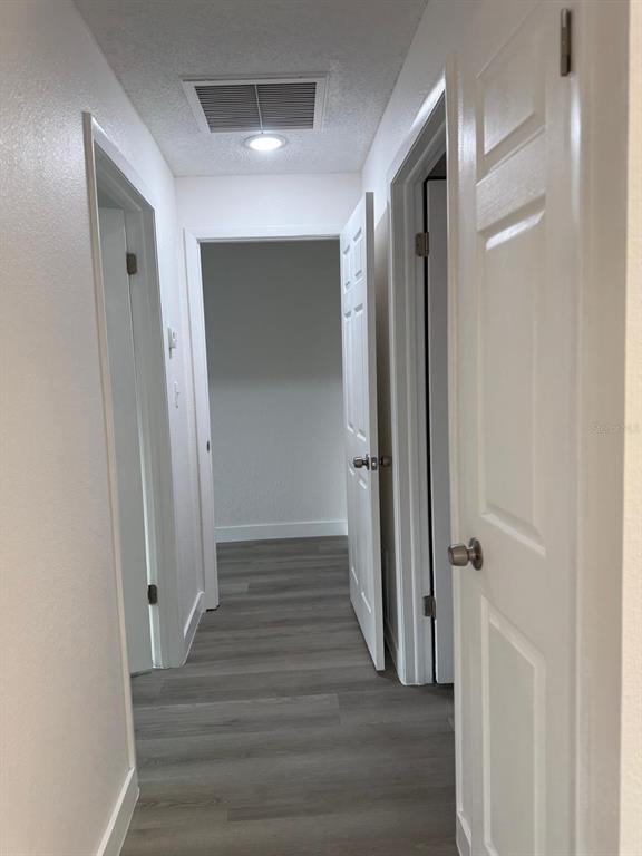 6125 Chesham Drive, Unit 1 New Port Richey, FL 34653 - Photo 23 of 39 a view of a hallway with wooden floor and staircase