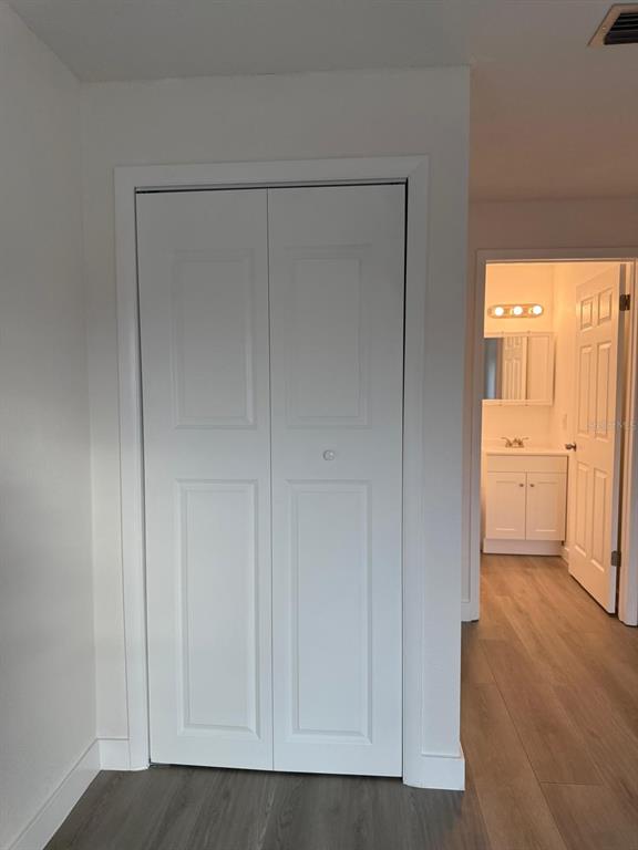 6125 Chesham Drive, Unit 1 New Port Richey, FL 34653 - Photo 26 of 39 a view of an empty room with wooden floor and a bathroom