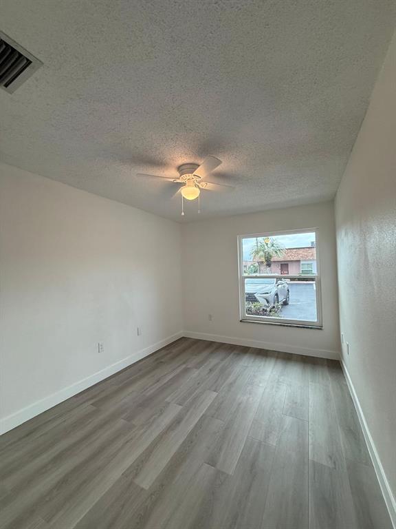 6125 Chesham Drive, Unit 1 New Port Richey, FL 34653 - Photo 32 of 39 a view of an empty room with wooden floor and a window
