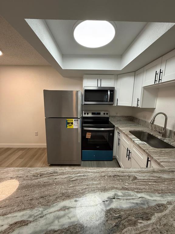 6125 Chesham Drive, Unit 1 New Port Richey, FL 34653 - Photo 9 of 39 a kitchen with stainless steel appliances granite countertop a refrigerator a stove a sink and a microwave