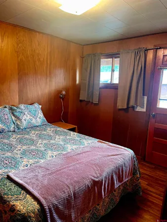 a bedroom with a bed lamps and wooden floor