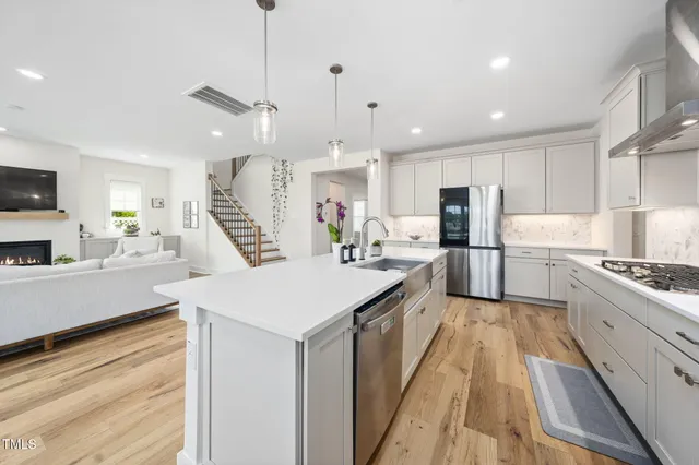 a large white kitchen with lots of counter space a sink appliances and cabinets
