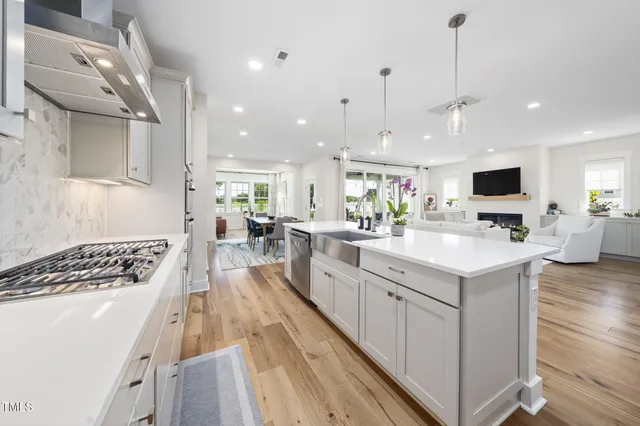a large white kitchen with lots of counter space a sink appliances and cabinets