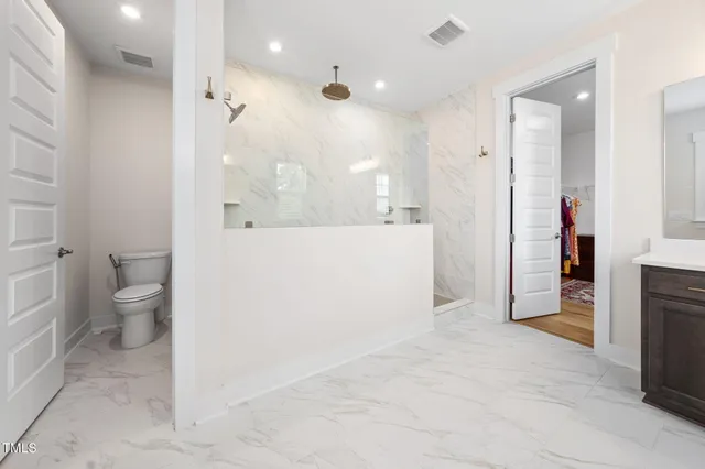 a bathroom with a toilet a sink and a mirror