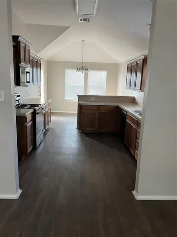 a kitchen with stainless steel appliances granite countertop a stove a sink and a refrigerator