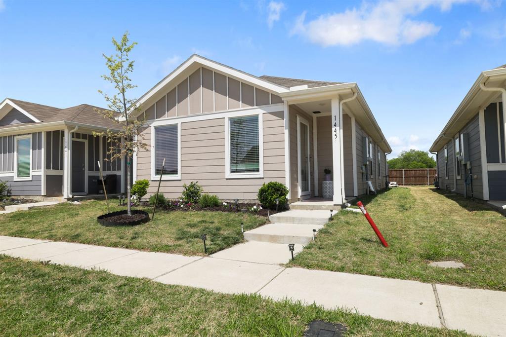 1445 Sterling Way Ferris, TX 75125 - Photo 1 of 17 View of front of house featuring a front yard and board and batten siding