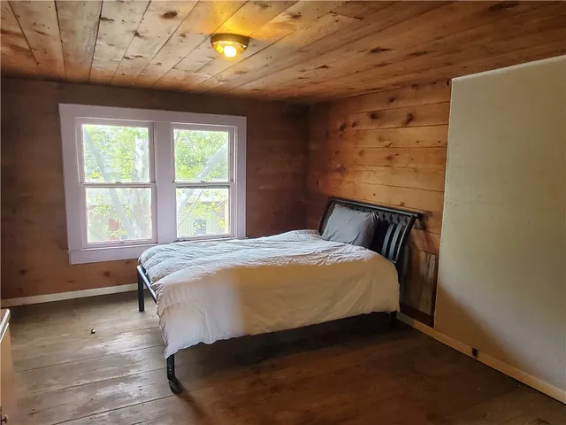 a bed sitting in a bedroom next to a window
