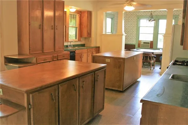 a view of kitchen with kitchen island a sink a counter top space and living room area