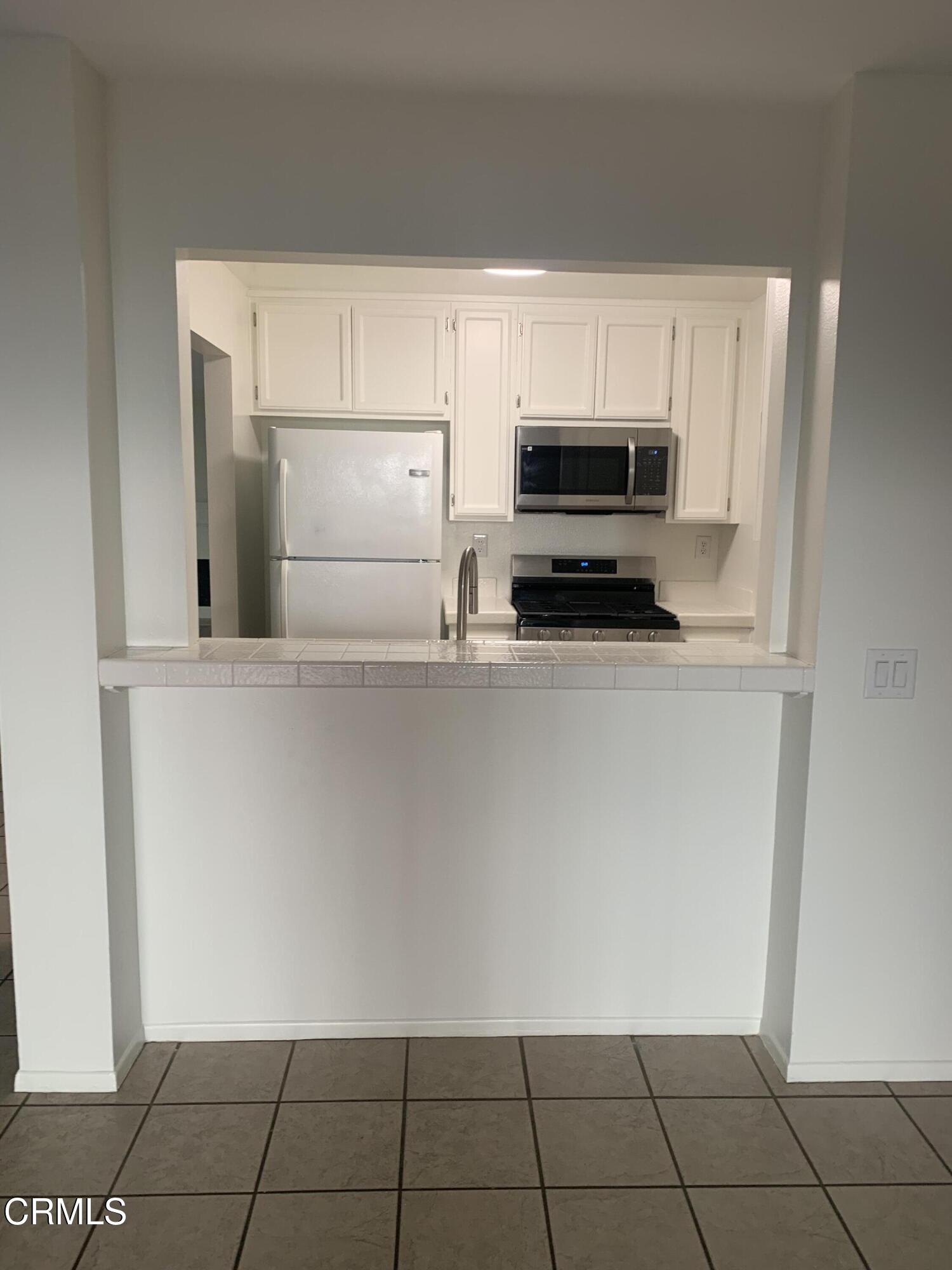 4455 Antigua Way Oxnard, CA 93035 - Photo 17 of 26 a kitchen with granite countertop a cabinets and a stove top oven