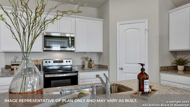 1008 Village Run Seguin, TX 78155 - Photo 17 of 39 a kitchen with stainless steel appliances granite countertop a stove a microwave a sink and cabinets