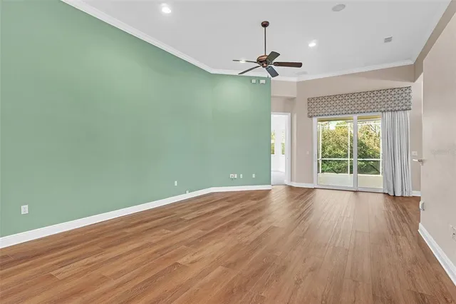 an empty room with a window and a fan