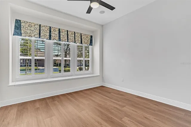a view of a brick house with a yard and large tree