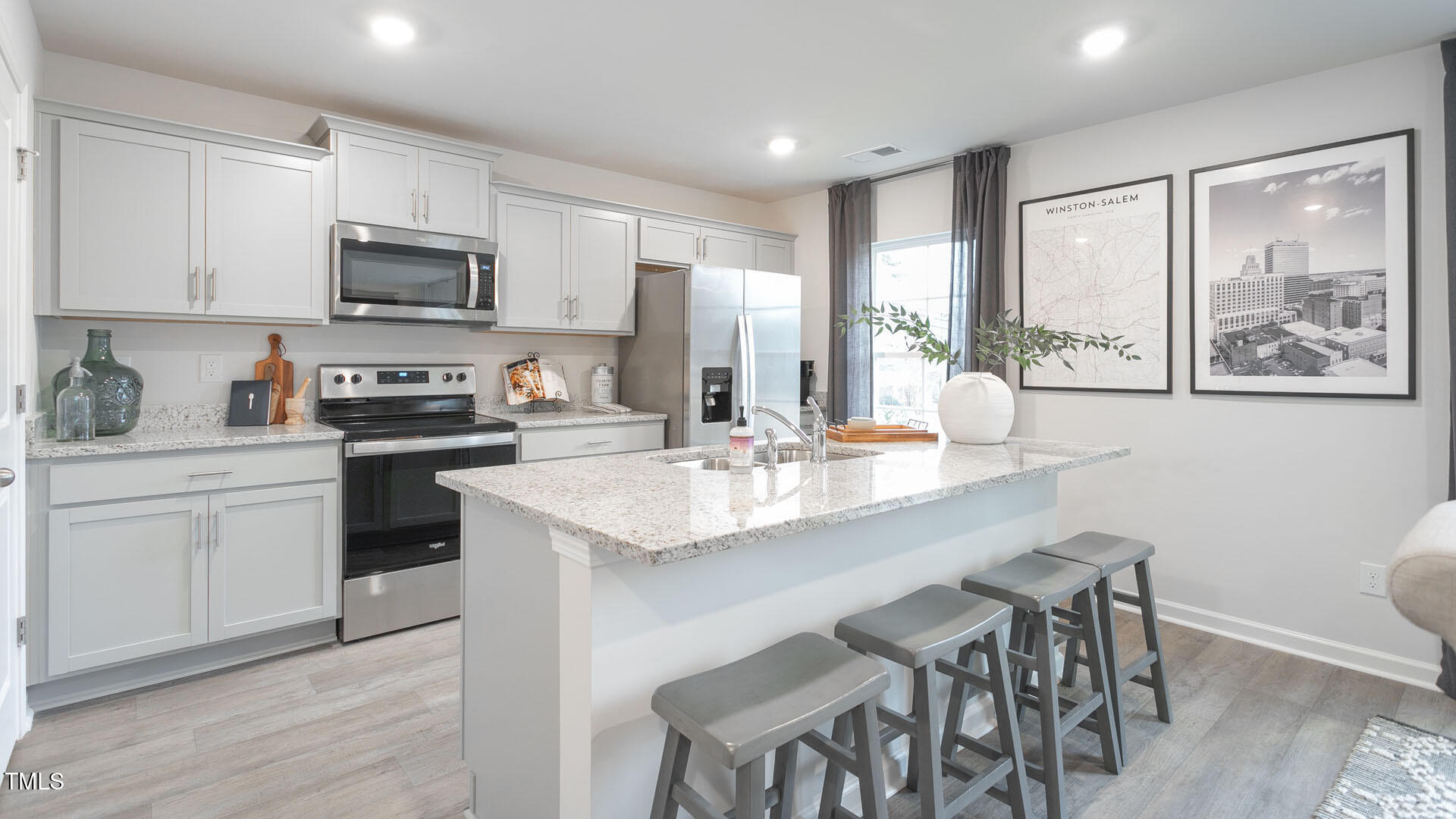 5901 Sodium Street Raleigh, NC 27610 - Photo 5 of 23 a kitchen with stainless steel appliances granite countertop a table chairs microwave and sink
