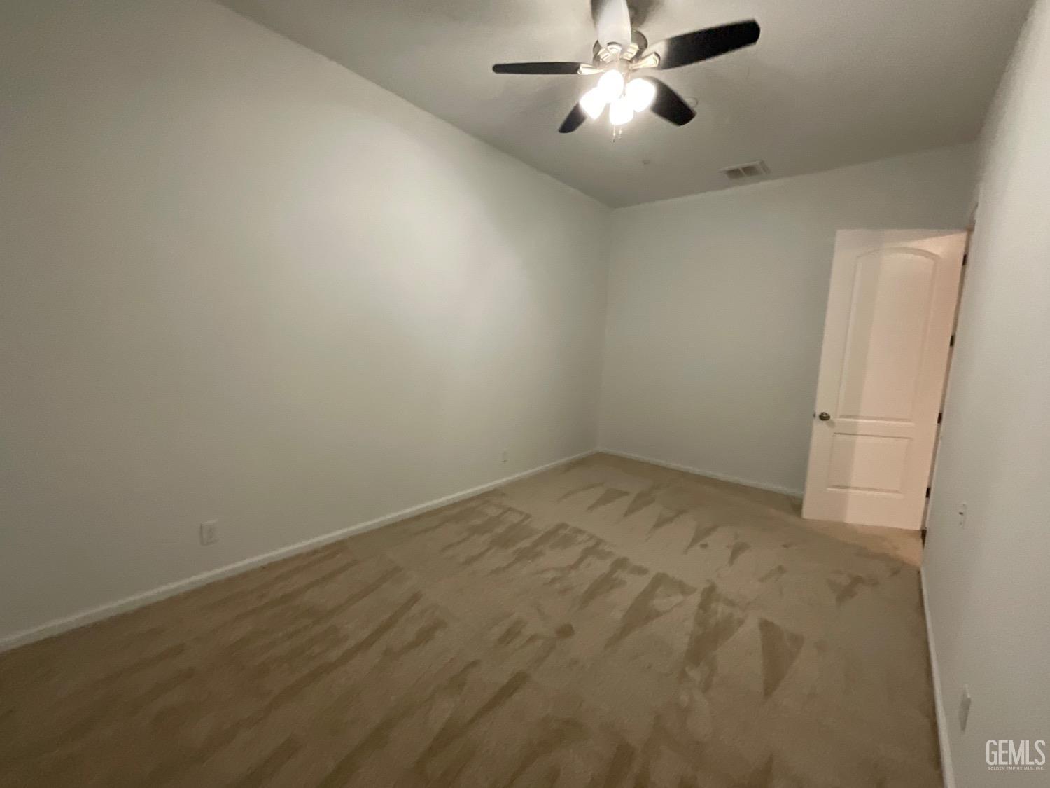 Undisclosed Address Bakersfield, CA 93314 - Photo 23 of 31 an empty room with a chandelier fan and windows