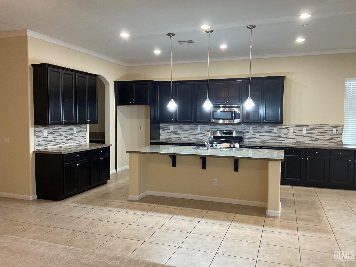 Undisclosed Address Bakersfield, CA 93314 - Photo 3 of 31 a large kitchen with stainless steel appliances kitchen island granite countertop a stove a sink and a refrigerator