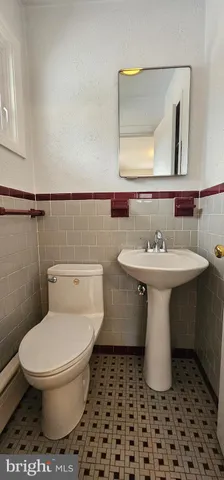 a bathroom with a sink toilet and a mirror