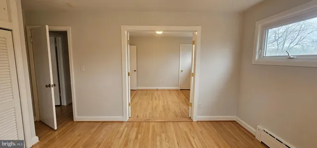 a view of wooden floor in an empty room with a window