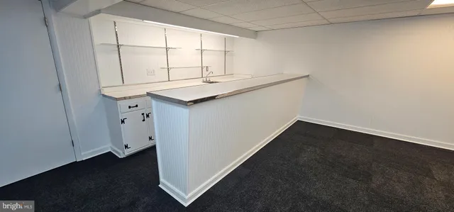 an empty room with wooden floor and white cabinet