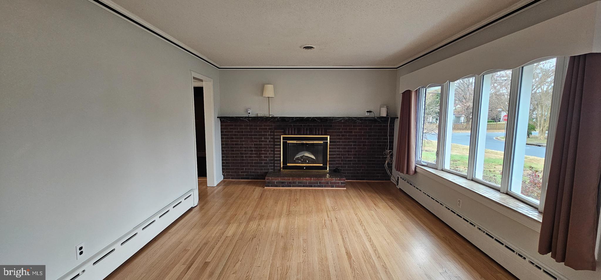 4202 Yates Road Beltsville, MD 20705 - Photo 3 of 35 a view of an empty room with wooden floor fireplace and a window